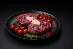 Fresh raw beef steak with bone or ossobuco with salt, spices and herbs photo