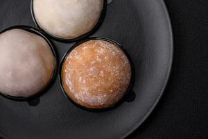 Delicious sweet mochi dessert with toppings on a dark concrete background photo