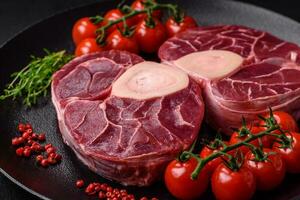 Fresh raw beef steak with bone or ossobuco with salt, spices and herbs photo