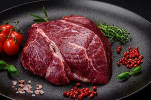 Fresh raw beef steak with salt, spices and herbs photo