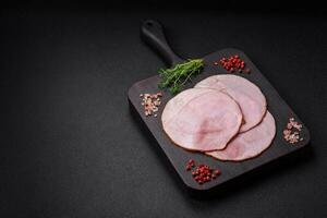 Delicious fresh ham cut into round slices with salt, spices and herbs photo