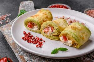 Delicious healthy vegetarian vegetable roll of zucchini, tomatoes, peppers and sauce photo