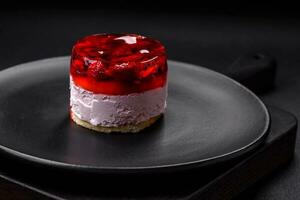 Delicious fresh sweet cheesecake cake with berries and red color jelly photo