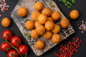 Delicious fried potato balls with breaded mozzarella, salt, spices and herbs photo