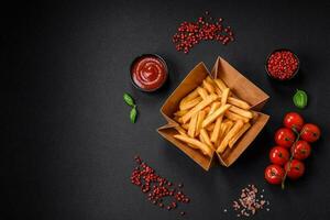 Delicious crispy french fries with salt and spices in a cardboard box photo