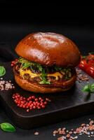 Burger with juicy beef cutlet, cheese, tomatoes, salt, spices and herbs photo