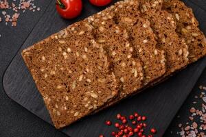 Delicious fresh crispy brown bread with seeds and grains cut into slices photo