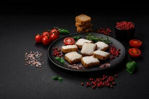 Delicious salty rectangular wheat croutons with cream cheese and tomatoes photo