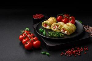 Delicious healthy vegetarian vegetable roll of zucchini, tomatoes, peppers and sauce photo