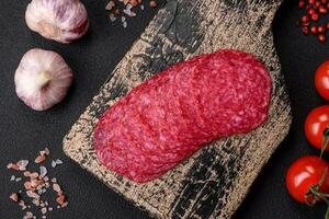 Delicious smoked salami sausage with salt, spices and herbs cut into slices photo