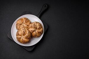 Delicious freshly baked crispy bun or kaiser roll with sesame seeds photo