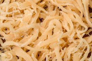 Delicious dried squid in the form of shavings with salt and spices on a ceramic plate photo