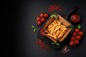 Delicious crispy french fries with salt and spices in a cardboard box photo