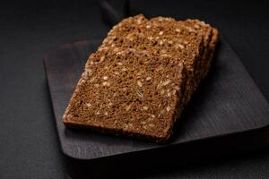 Delicious fresh crispy brown bread with seeds and grains cut into slices photo