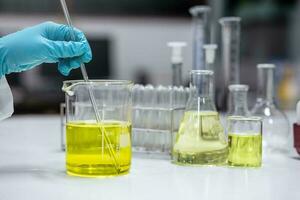 Scientist prepare a solution of an emulsifier in a beaker for formulation test of the cosmetic product in the laboratory. Research and Development cosmetics. photo