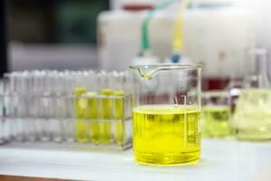 pálido amarillo solución de un emulsionante un cubilete para formulación prueba de el cosmético producto en el laboratorio o industria. investigación y desarrollo productos cosméticos. foto
