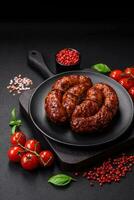 Delicious grilled sausage in the form of a ring with salt, spices and herbs photo