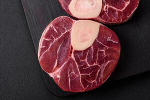 Fresh raw beef steak with bone or ossobuco with salt, spices and herbs photo