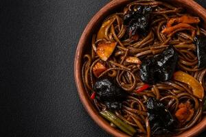 Delicious fresh buckwheat noodles or udon with mushrooms, peppers and other vegetables photo