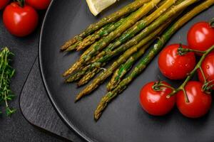 Delicious nutritious breakfast consisting of asparagus, tomatoes, salt, spices and herbs photo