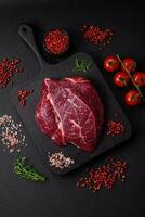 Fresh raw beef steak with salt, spices and herbs photo