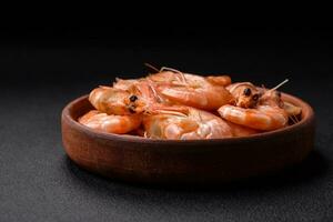 Delicious fresh boiled tiger prawns with salt and spices on a ceramic plate photo