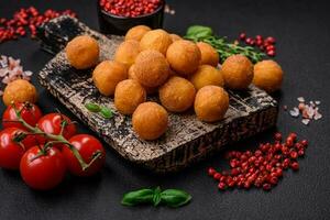 Delicious fried potato balls with breaded mozzarella, salt, spices and herbs photo