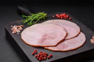 Delicious fresh ham cut into round slices with salt, spices and herbs photo