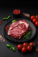 Fresh, raw beef steak with salt, spices and herbs photo