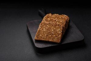 Delicious fresh crispy brown bread with seeds and grains cut into slices photo