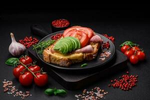 Delicious nutritious grilled toast with ham, cheese, tomatoes and avocado photo