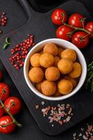 Delicious fried potato balls with breaded mozzarella, salt, spices and herbs photo