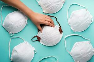 Hand holding a respirator masks to prevent coronavirus and various diseases - flat lay photo