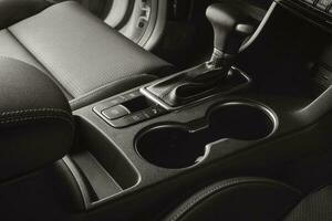 Vehicle interior with black leather seats and automatic gear lever photo