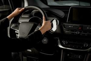 Elegant business woman with suit driving a new chinese car - hands holding steering wheel photo