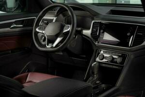 New automobile interior details with leather steering wheel, automatic transmission and touchscreen center console photo