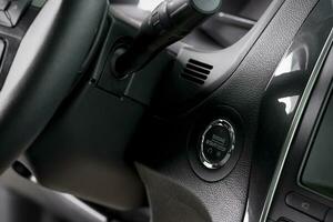 close up start stop button and windscreen wiper switch inside a new car photo