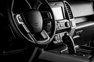 Car interior dashboard with modern details, multimedia screen system, gear lever and luxury concept - black and white photo