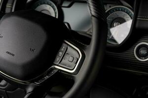 New car interior steering wheel, digital speedometer close up photo