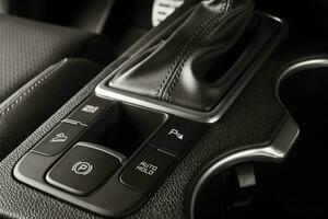electrónico freno de mano botón en un nuevo coche con lujoso y moderno detalles foto
