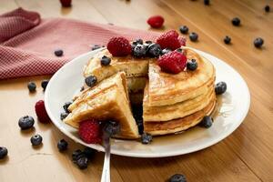 Fluffy pancakes with blueberries and raspberries - Hotcakes photo