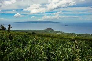 In the distance, the Hawaiian island of Lanai is visible, as are sugar cane fields in the foreground. photo