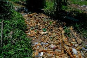 Piles of waste left over from plastic beverage bottles in ditches which cause water to clog and not flow can cause flooding photo