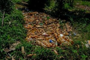 Piles of waste left over from plastic beverage bottles in ditches which cause water to clog and not flow can cause flooding photo