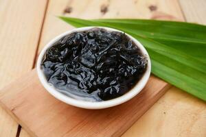 selective focus on grated black grass jelly on a white bowl. soft focus photo