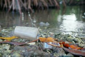 selectivo atención a el plastico taza residuos con desenfocado mangle bosque antecedentes. concepto foto de ambiental contaminación alrededor el mar y mangle bosques