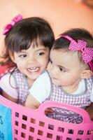 Beautiful ten months baby girl playing with her sister. Early stimulation for toddlers and children concept. photo