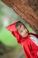 Sweet girl wearing a Little red riding hood costume. Real family having fun while using costumes of the Little red riding hood tale in Halloween. photo