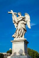 Beautiful Angel with the Cross statue created by Ercole Ferrata on the 16th century at Sant Angelo Bridge in Rome photo