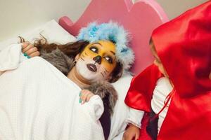 Real family having fun while using costumes of the Little red riding hood tale in Halloween. photo